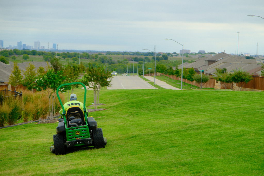 Site Landscape Development worker mowing a field near Fort Worth