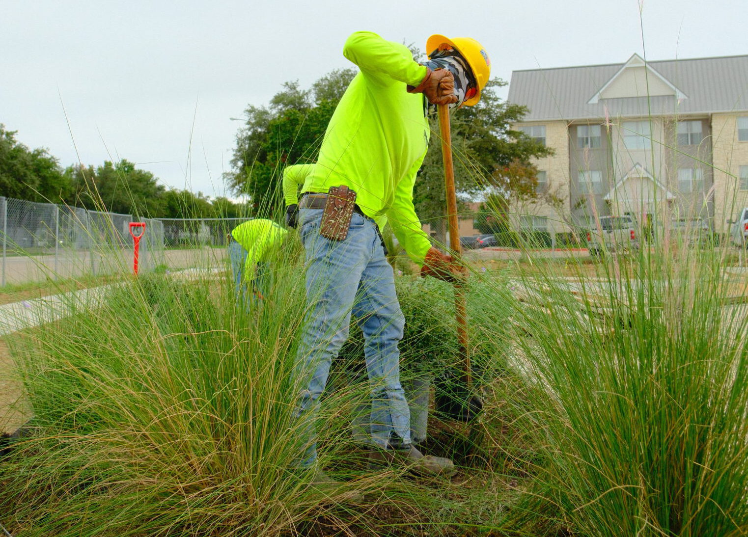 Site landscapers performing plant and irrigation work at a commercial property