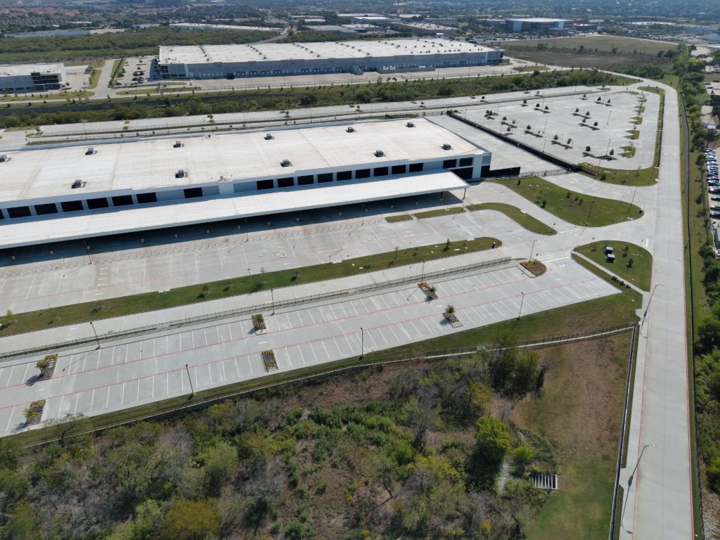 Aerial view of a large commercial distribution facility and landscaped parking areas in Fort Worth, Texas.