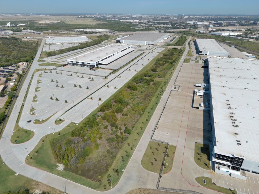Aerial view of a large commercial distribution facility and landscaped parking areas in Fort Worth, Texas.