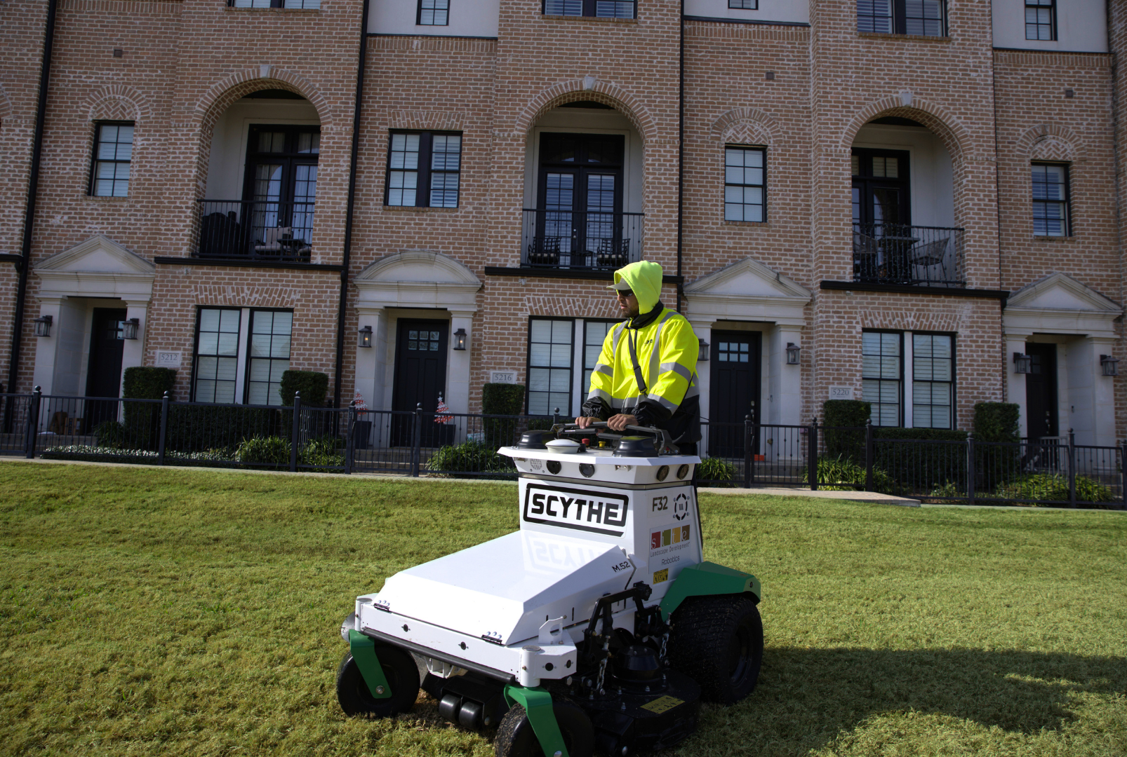 SLD crew member operating a Scythe mower at a commercial site in the DFW area.