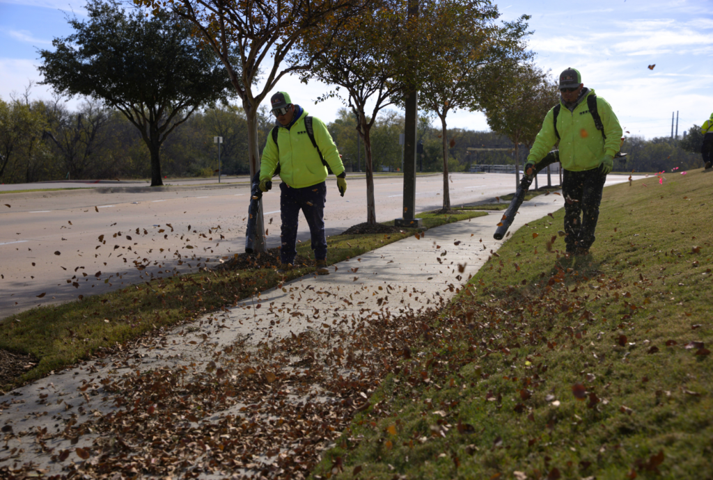 SLD crew members using leaf blowers during landscape maintenance.