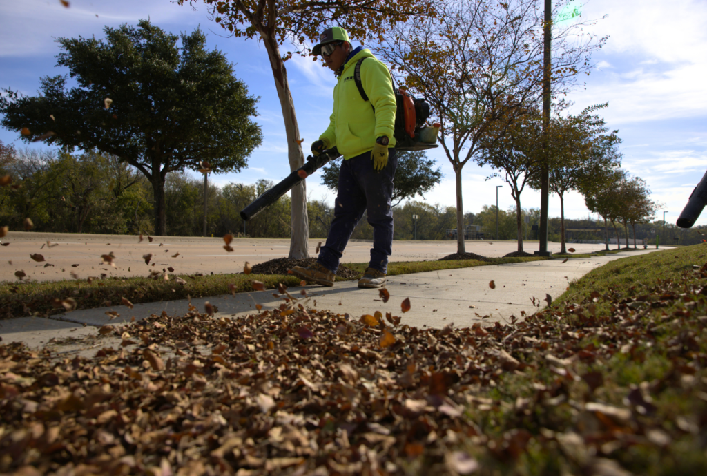 SLD crew members using leaf blowers during landscape maintenance.