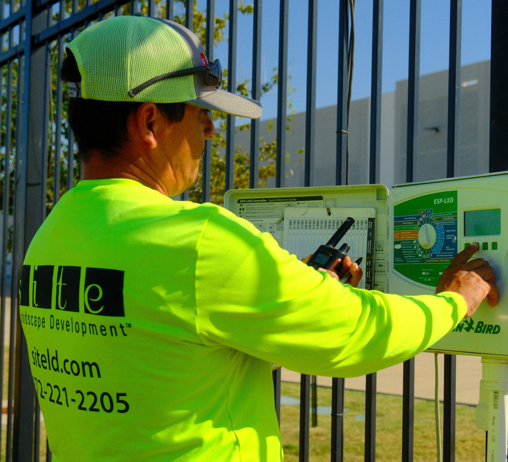 SLD crew member inspecting an irrigation control box at a commercial property.