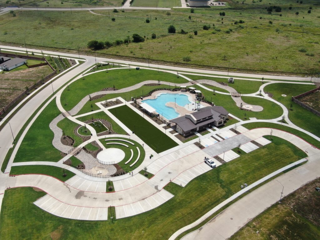 The completed Rock Creek West amenity center in southwest Fort Worth, featuring new landscaping, sod, trees, shrubs, flower beds, rockscape, and river rock installed by SLD.