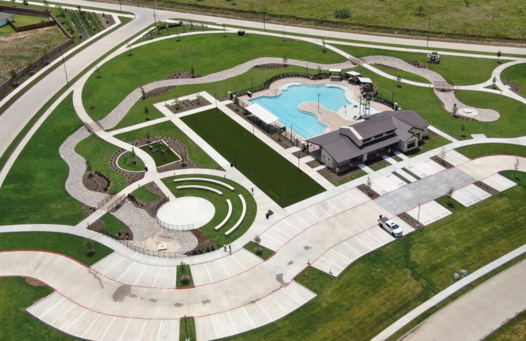The completed Rock Creek West amenity center in southwest Fort Worth, featuring new landscaping, sod, trees, shrubs, flower beds, rockscape, and river rock installed by SLD.