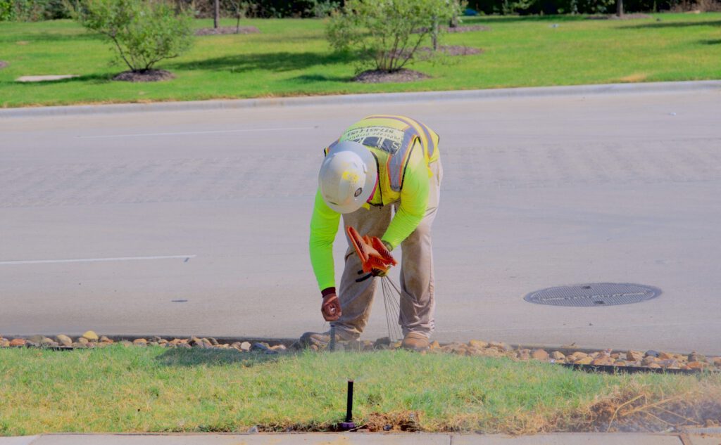 SLD crew placing locating flags and checking irrigation against plan at a commercial construction project in North Texas.