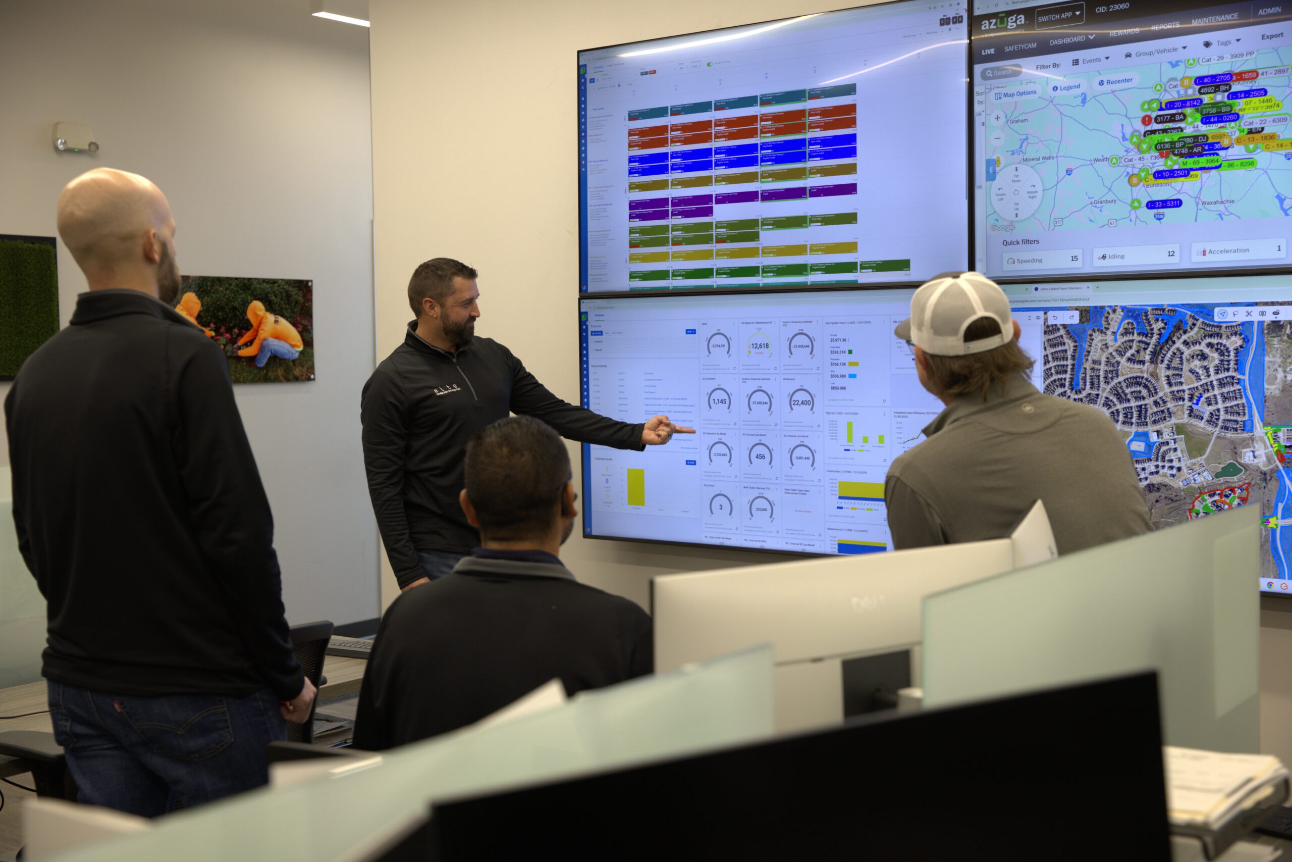 SLD team members reviewing scheduling, mapping, fleet, and performance dashboards on large digital screens during an operations meeting.