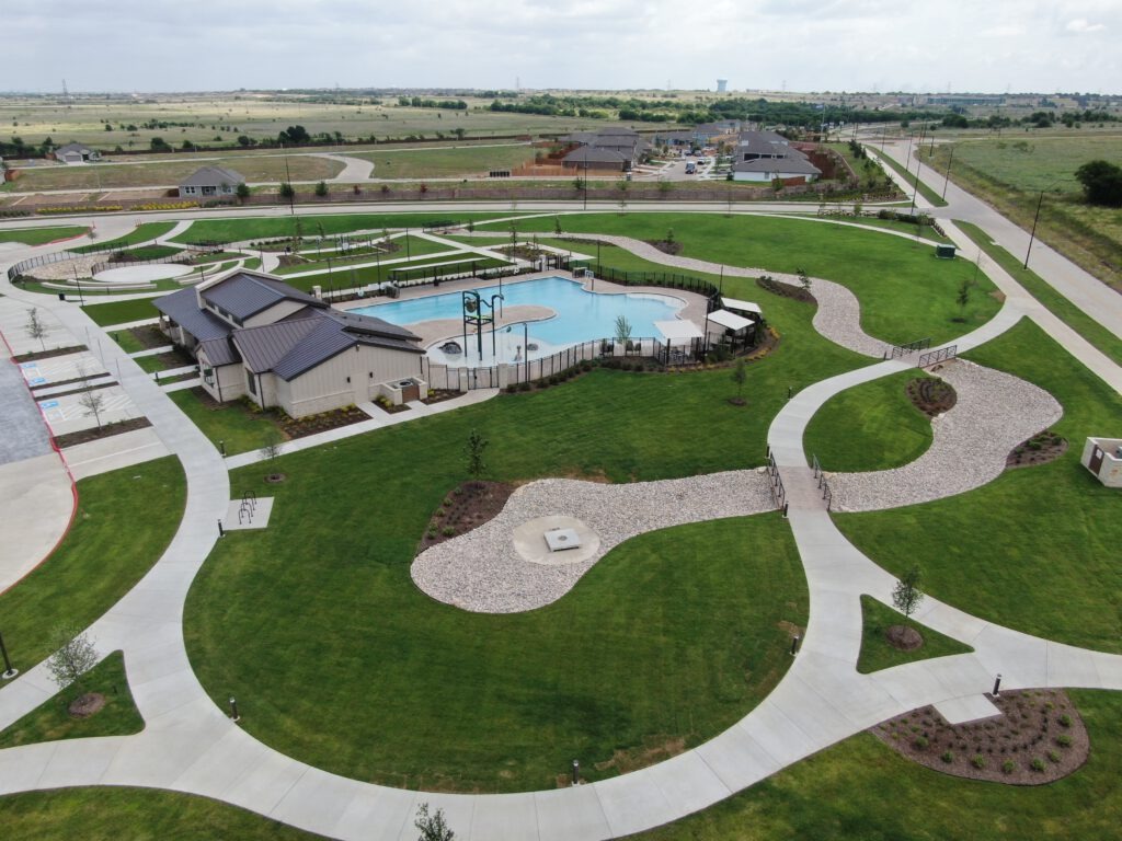 The completed Rock Creek West amenity center in southwest Fort Worth, featuring new landscaping, sod, trees, shrubs, flower beds, rockscape, and river rock installed by SLD.
