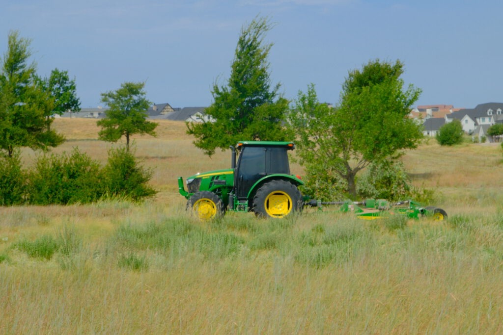 SLD crew member mowing a large open field at Walsh, a master-planned community in Fort Worth, TX.